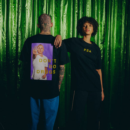 Two models in black Eminem PSA Don't Do Drugs T-shirts against a green bamboo backdrop