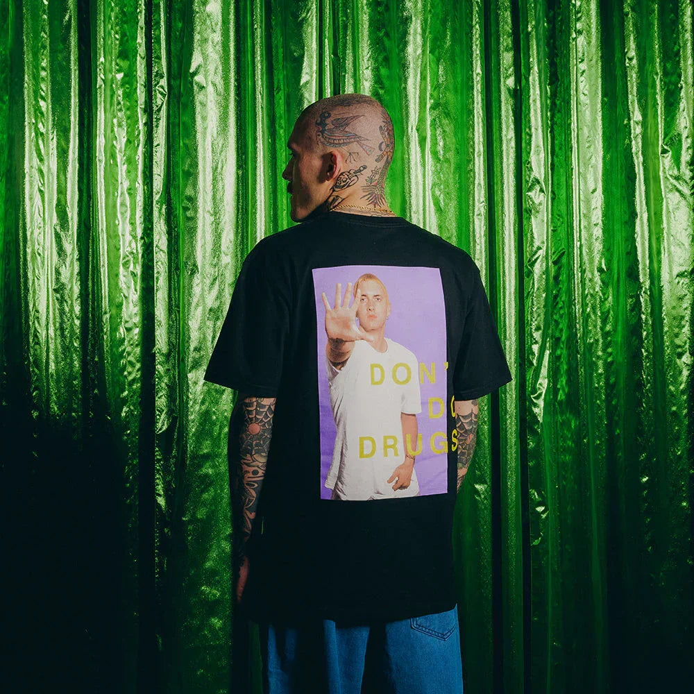 Man wearing the black Eminem PSA T-shirt with purple Don't Do Drugs photo panel print