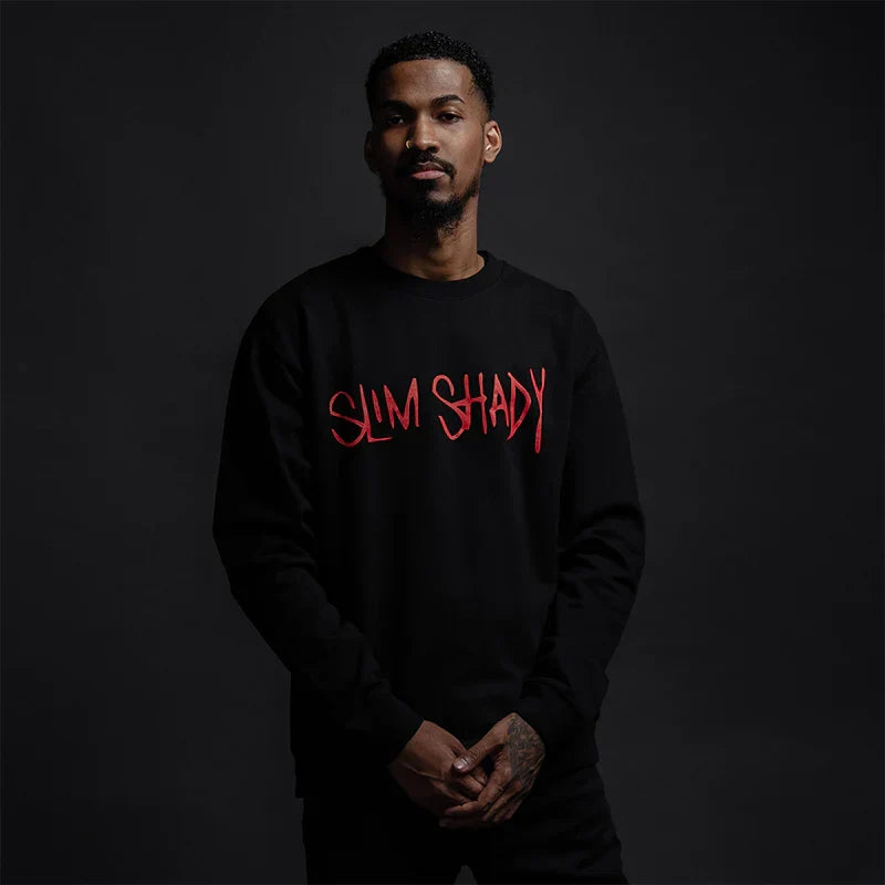 Man wearing the black Eminem Slim Shady crewneck with red graffiti chest print