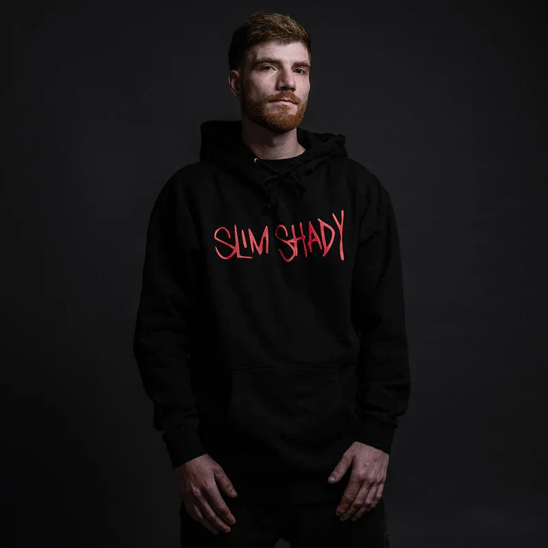 Man wearing the black Eminem Slim Shady hoodie with red graffiti chest print