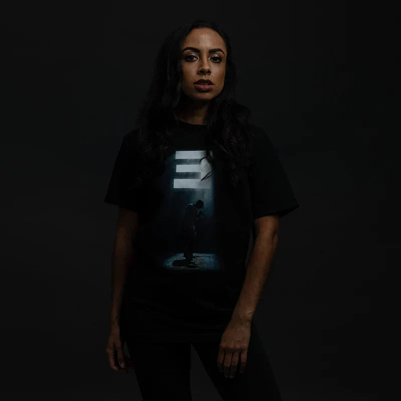 Woman wearing the black Eminem Stage Lights T-shirt, spotlight silhouette graphic