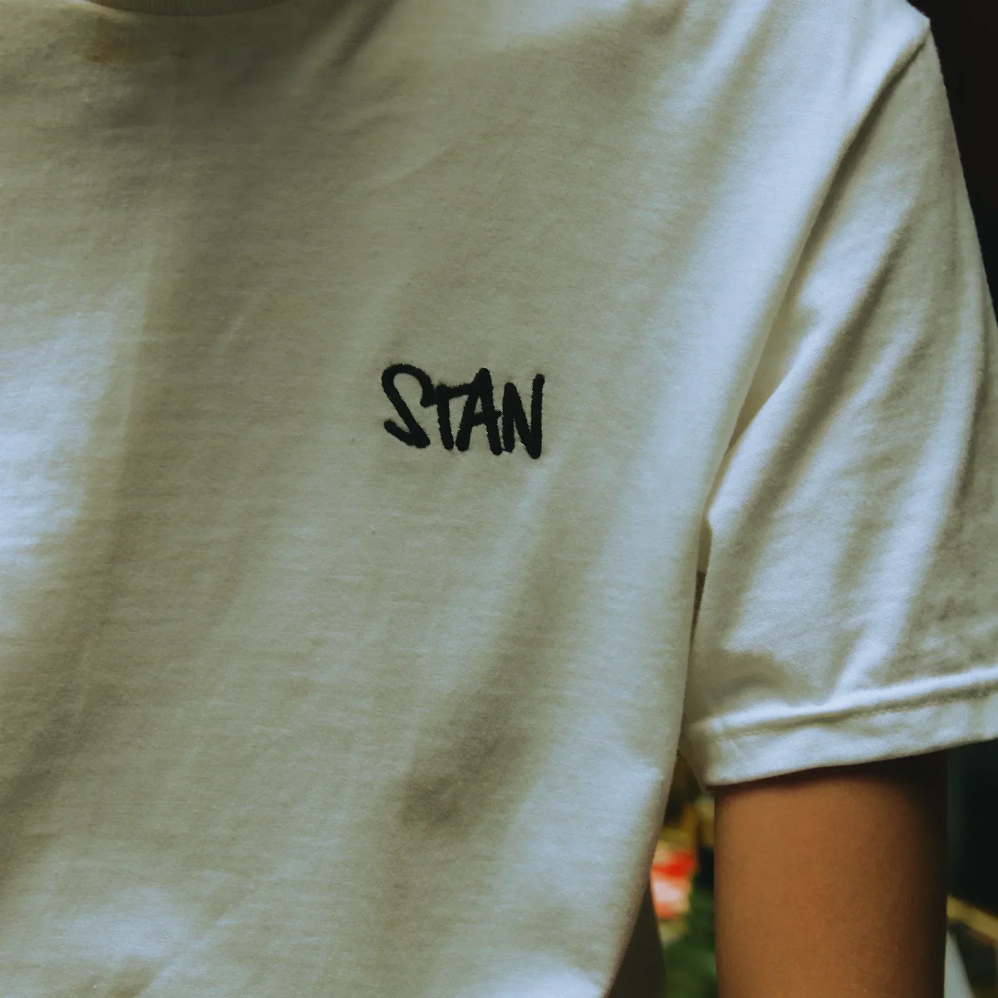 Close-up of the black Stan embroidery on the white Eminem T-shirt sleeve