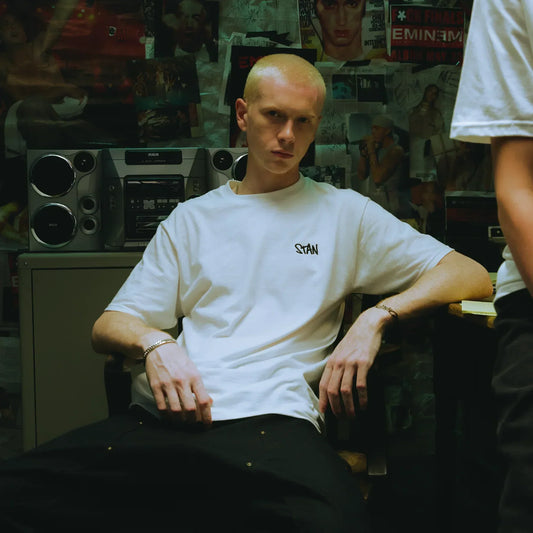 Man wearing the white Eminem Stan embroidered T-shirt in a record store setting