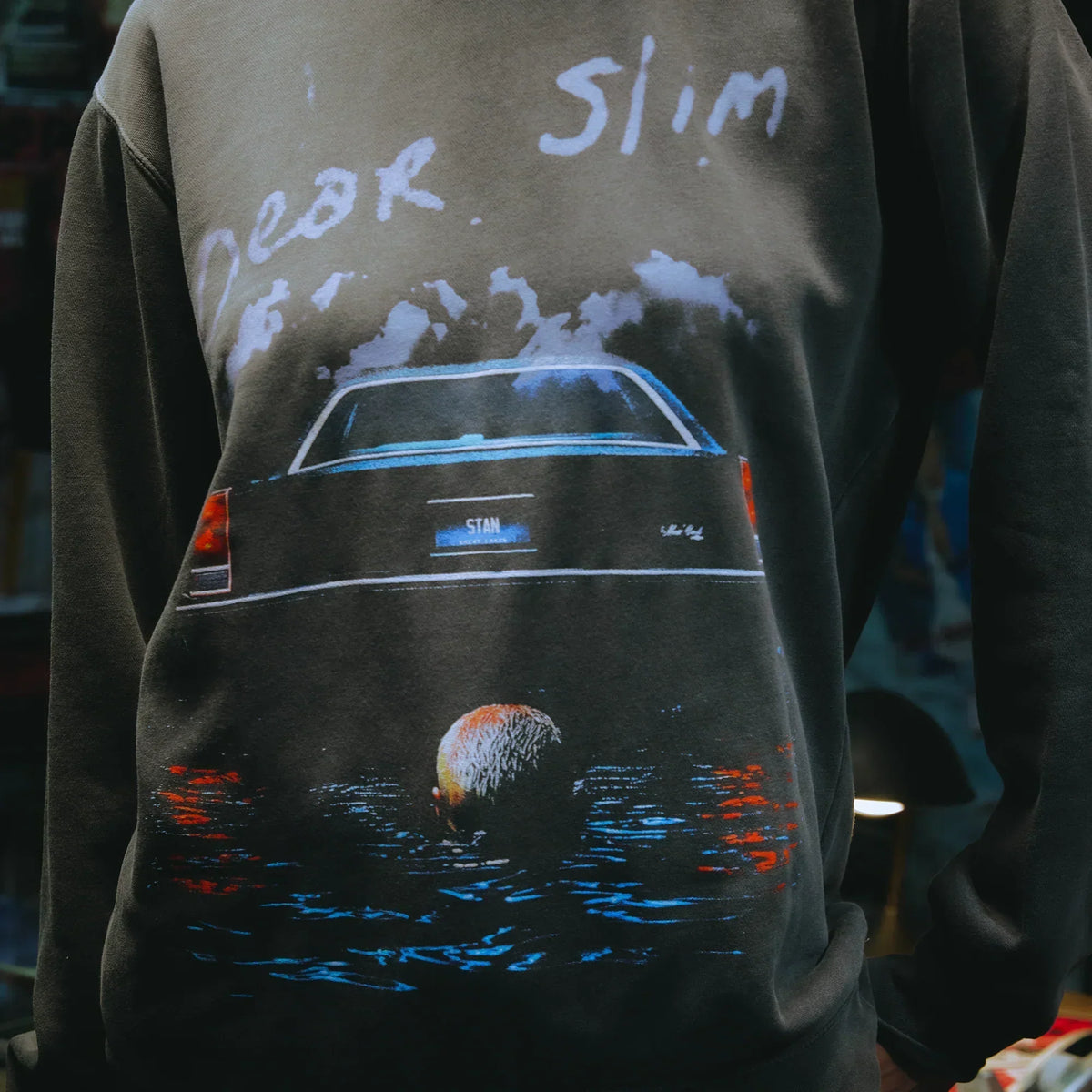 Front print detail of the Eminem Dear Slim crewneck, sinking car artwork over water