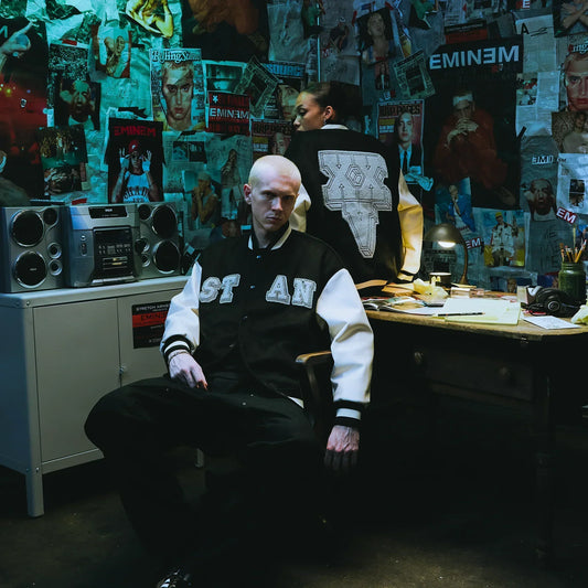 Model in the Eminem Stan varsity jacket in a room papered with magazine covers
