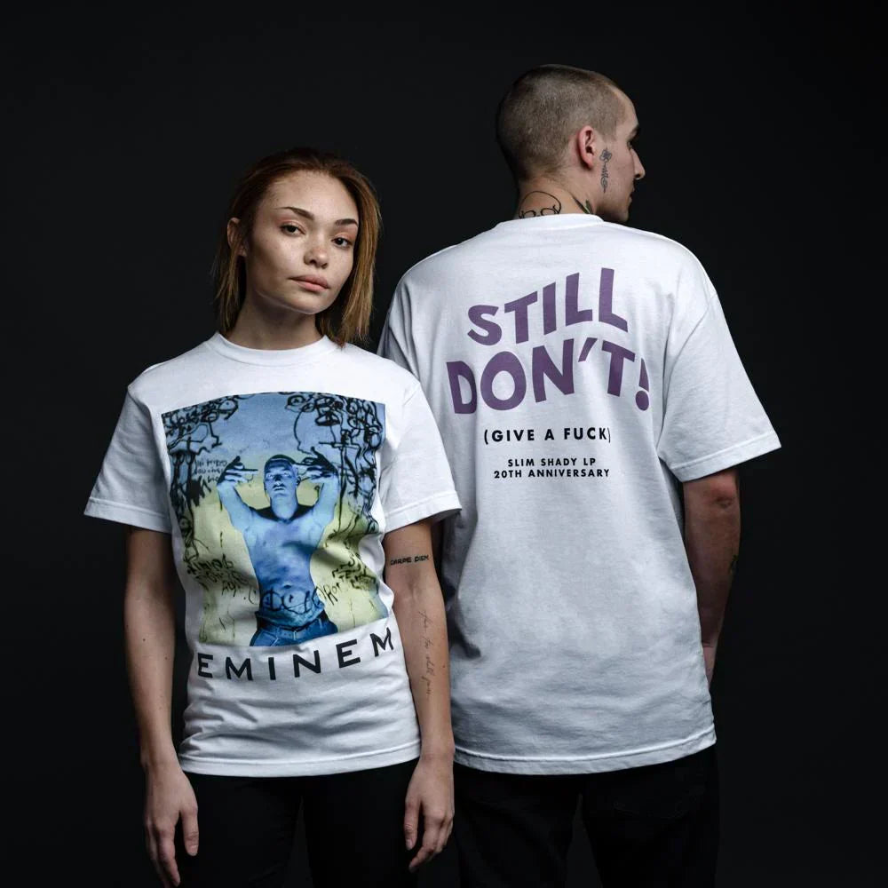 Two models in white Eminem Still Don't T-shirts showing front photo and back type prints