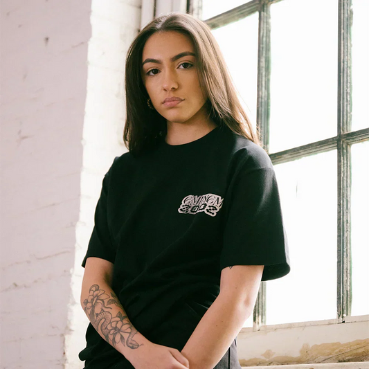 Woman wearing the black Eminem Show Chrome Logo T-shirt by a factory window