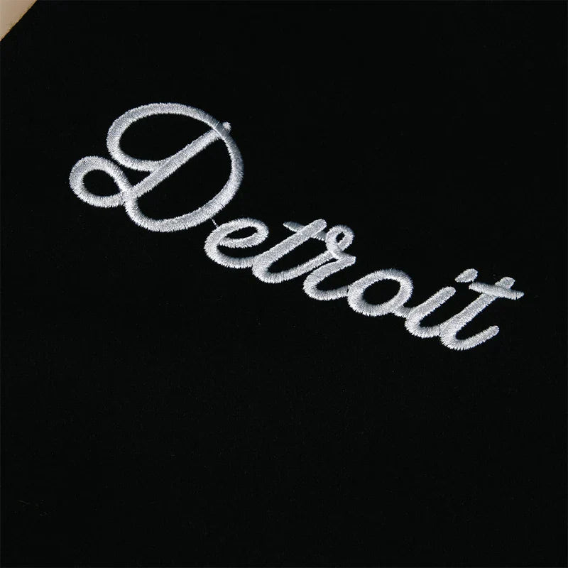 Detroit chain-stitch script detail on the black Eminem SSLP25 varsity jacket