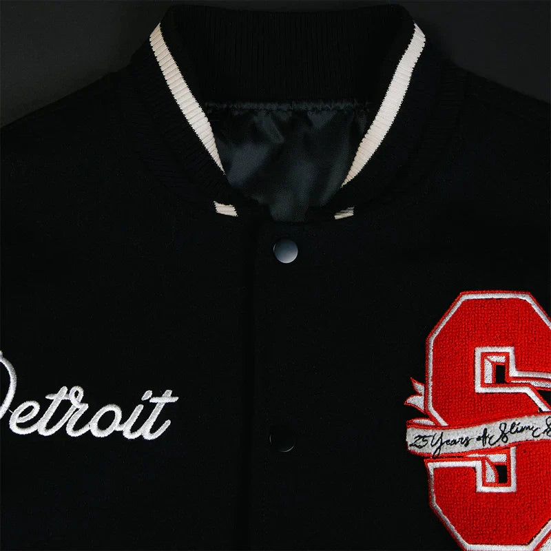 Collar and chest detail of the Eminem SSLP25 varsity jacket with Detroit and S patches
