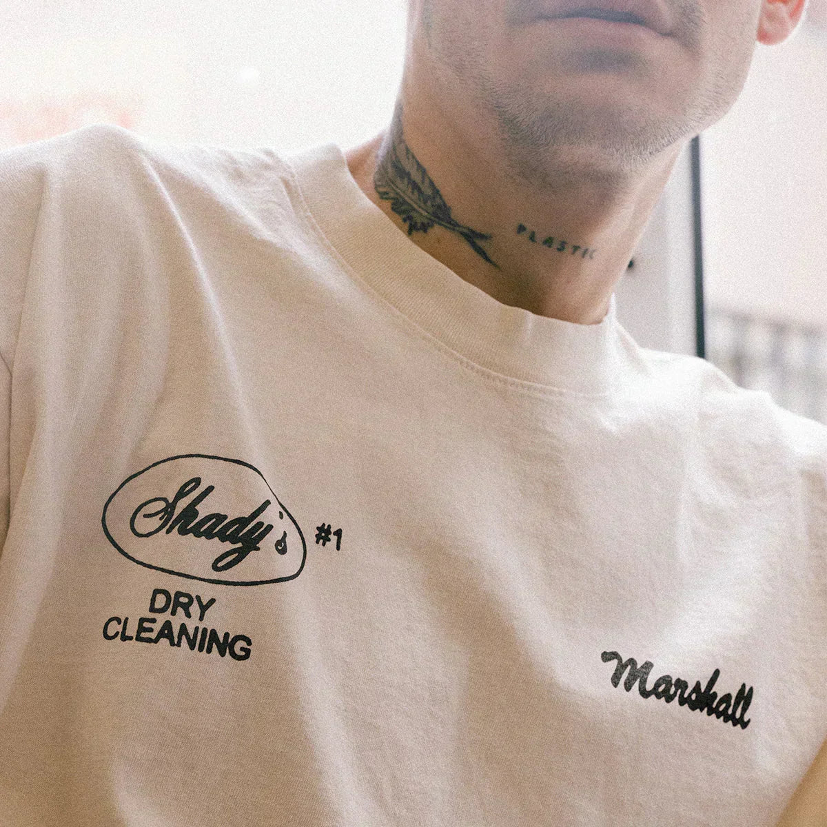 Close-up of the Shady's Dry Cleaning and Marshall chest prints on the cream Eminem T-shirt