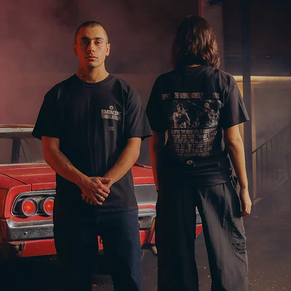 Two models in black Eminem Berzerk lyric T-shirts beside a red muscle car, front and back prints