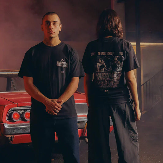 Two models in black Eminem Berzerk lyric T-shirts beside a red muscle car, front and back prints