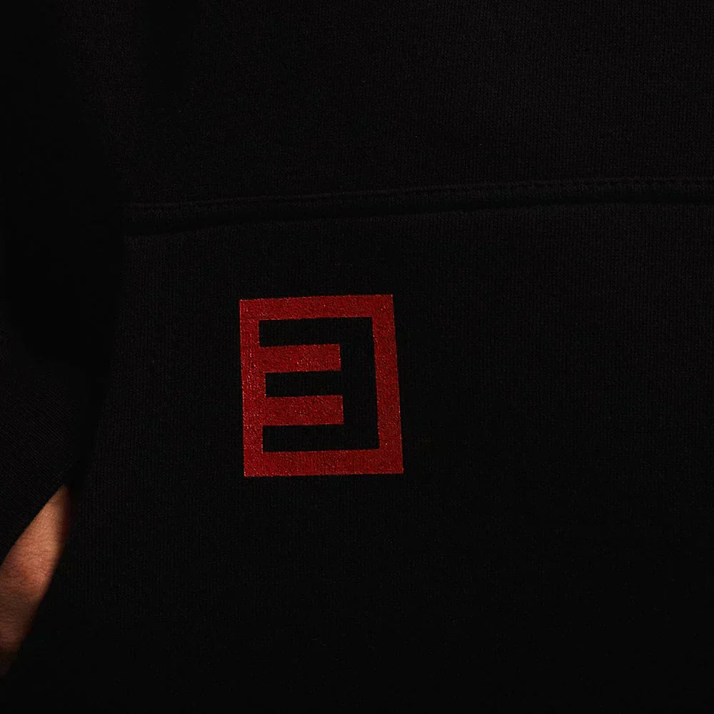 Red Eminem E logo print on the pocket of the black Eminem x Fortnite hoodie
