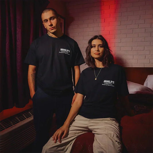 Man and woman wearing black Eminem MMLP2 Condemned anniversary T-shirts, small chest logo