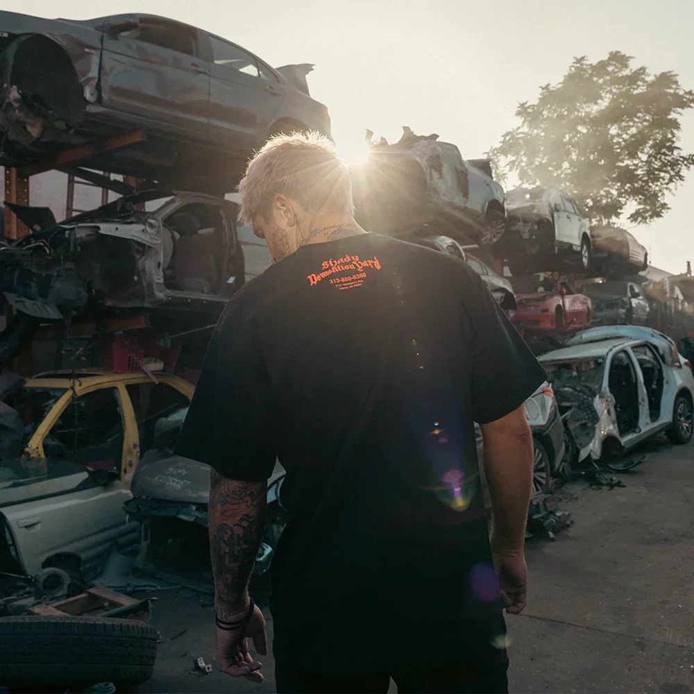 Back of the black Eminem Shady Demolition Logo T-shirt worn in a scrapyard at sunset