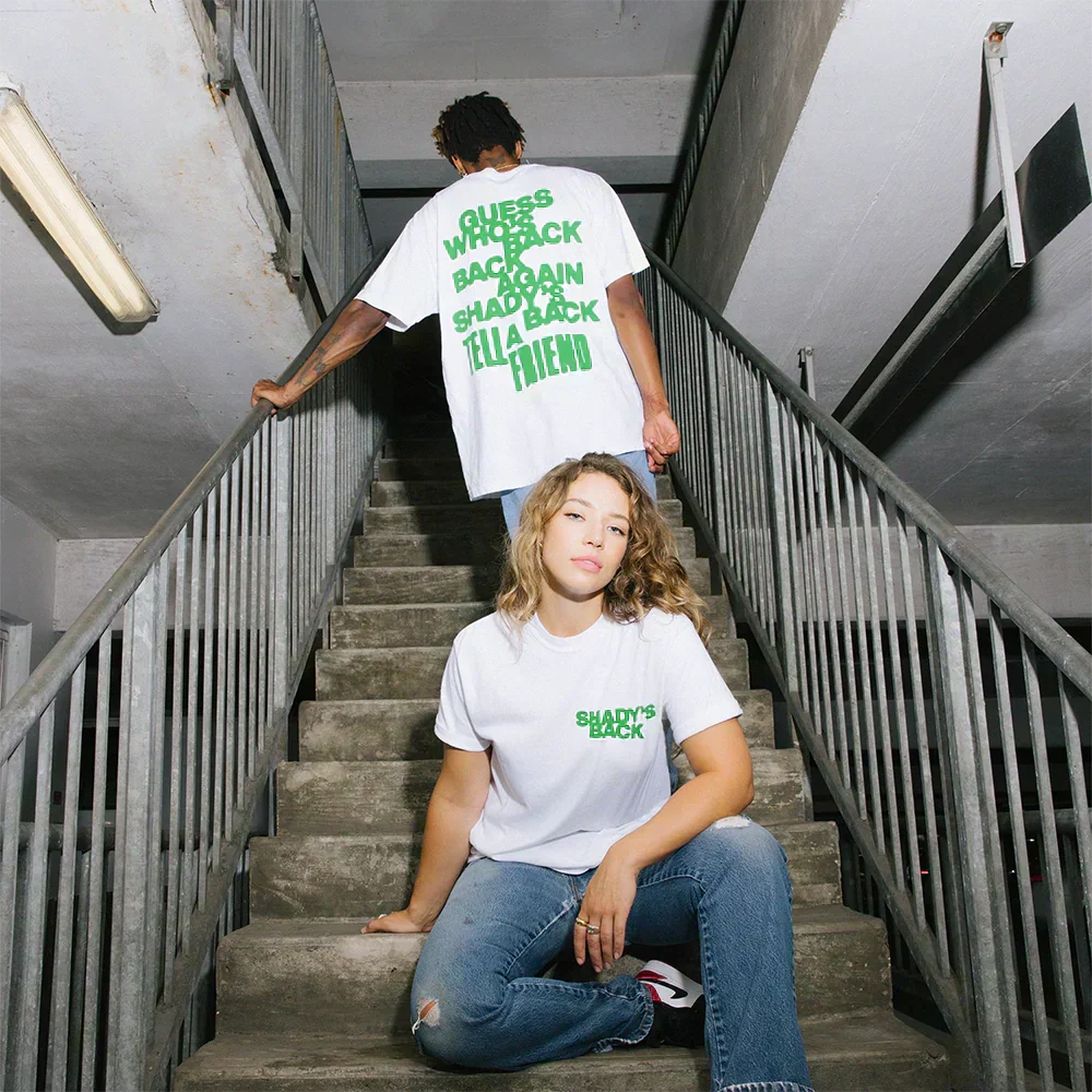 Two models in white Eminem Show 20th Anniversary Shady's Back T-shirts on a stairwell