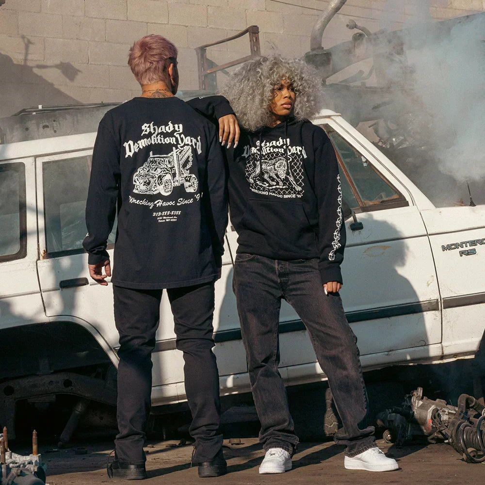 Two models in Eminem Shady Demolition Junkyard Dog hoodies in a scrapyard